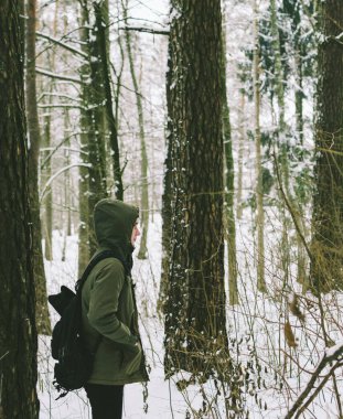 Genç adam kış ormanında