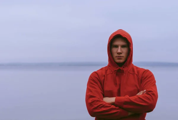 Deportista en capucha roja en el lago — Foto de Stock