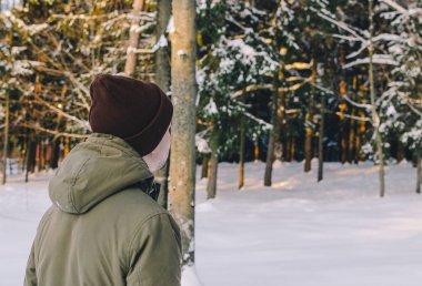 Genç adam kış ormanında