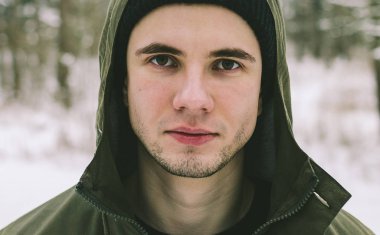 Genç adam kış ormanında