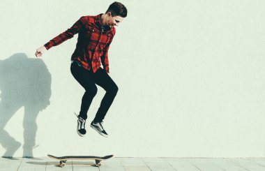 Genç adam kaykaya biniyor. 