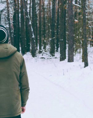 Genç adam kış ormanında
