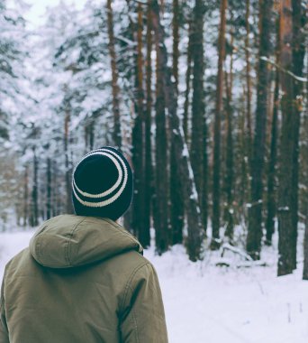 Genç adam kış ormanında