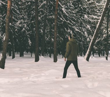 Genç adam kış ormanında