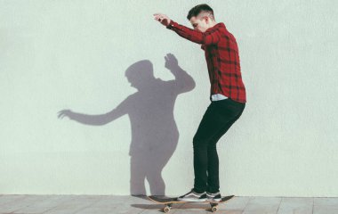 Genç adam kaykaya biniyor. 