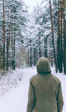 Genç adam kış ormanında