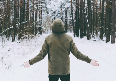 Genç adam kış ormanında