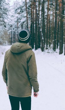 Genç adam kış ormanında