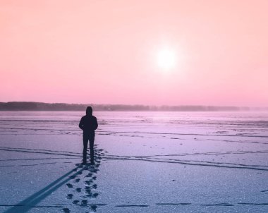 Genç adam donmuş göl üzerinde