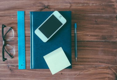 Defter ve telefon ahşap masada.