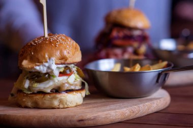 Burger bar: ızgara hamburger, turşulu, krem peynirli ve biftekli. Arka planda büyük bir burger daha. Popüler sokak yemekleri konsepti