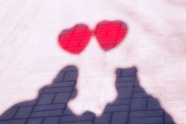 Imagen abstracta: sombra de pareja enamorada de dos globos rojos con forma de corazón. Concepto romántico — Foto de Stock