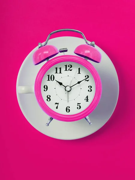 cup of clock. pink retro alarm clock on pink  background. Round alarm clock. ten hours ten minutes of the morning time to get up to wake up and have breakfast morning or evening jog to go to work