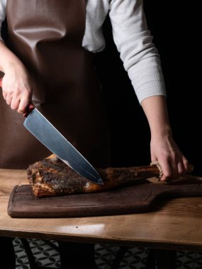 Gemide et kesmek için bıçak, jamon, kurutulmuş et, dana eti. Kuru jambon, Parma jambonu, siyah arka planda bütün bacak izole edilmiş. Kurumuş İtalyan bacağı. Tütsülenmiş biftek. Tahtada kurutulmuş sigara. Et dükkanı