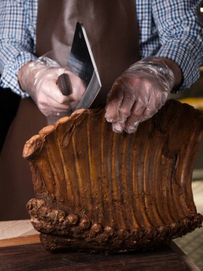 Şef füme bir kaburgayı baltayla keser. Tütsülenmiş domuz pirzolası. Tahtada et şarküteri var. Kuru kaburga. Et dükkanı. Şef et kesti.