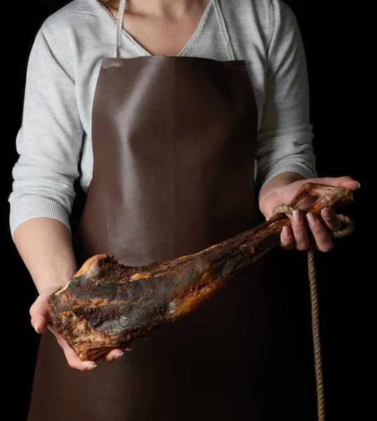Cutting meat on board with knife, jamon , beef jerky, veal. Dry  ham,  Parma ham, Whole leg isolated on black background. Leg of Italian dry-cured. Smoked beef.  Dry  smoked on wood board. Meat shop