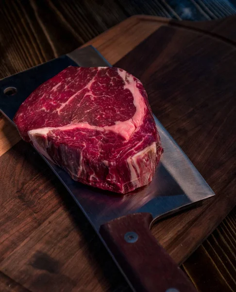 Rib eye steak on an ax. Raw Black Angus Beef Steak . Raw beef steak beef steak on a wooden board with an ax.