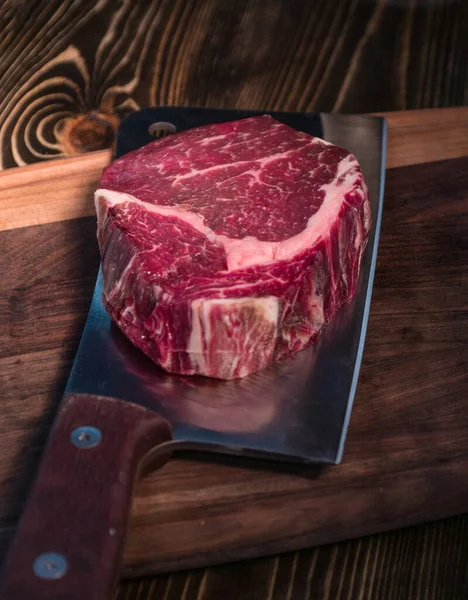 Rib eye steak on an ax. Raw Black Angus Beef Steak . Raw beef steak beef steak on a wooden board with an ax.