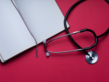 Doktor teşhis koronavirüsü hastalığı için siyah stetoskop, kırmızı arka planda fotokopi alanı olan sağlık için tıbbi araç. Foneendoskop kırmızı arka plan. Tıbbi aletler. metin için arka plan. boşluk dizüstü bilgisayarını kopyala