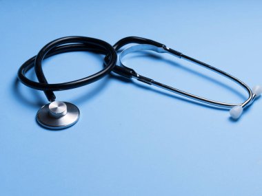 Doktor teşhis koronavirüsü hastalığı için siyah stetoskop, mavi arka planda fotokopi alanı olan sağlık için tıbbi araç. Phonendoskop ve siyah maskeli mor arka plan. Tıbbi araçlar