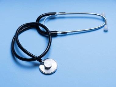 Doktor teşhis koronavirüsü hastalığı için siyah stetoskop, mavi arka planda fotokopi alanı olan sağlık için tıbbi araç. Phonendoskop ve siyah maskeli mor arka plan. Tıbbi araçlar