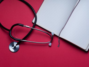 Doktor teşhis koronavirüsü hastalığı için siyah stetoskop, kırmızı arka planda fotokopi alanı olan sağlık için tıbbi araç. Foneendoskop kırmızı arka plan. Tıbbi aletler. metin için arka plan. boşluk dizüstü bilgisayarını kopyala