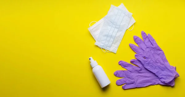 Tıbbi arka plan sarısı. Tıbbi maske, dezenfektan jeli ve laboratuvar eldivenleri Virüs koruma ekipmanında. Tehlikeli Asya Ncov Corona virüsü. Roman Coronavirus 2019-nCoV. dağıtıcı eldivenler ve maske 