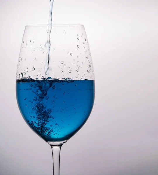 Copo Vinho Azul Com Água Salpicante Fundo Branco — Fotografia de Stock