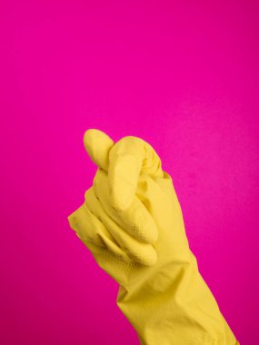  İzole edilmiş bir lateks eldiven verin. Eldivendeki bir el, yıkama ve temizleme için bir sünger tutar. Temizlik ya da temizlik konsepti. Mesaj ya da reklam çerçevesi. renkli arkaplan