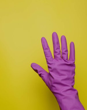 Renkli arka planda temizlik için lastik eldiven, ıslahevi konsepti. Genel ya da düzenli temizlik. Arka planda sarı lastik eldivenler. Temizlik servisi