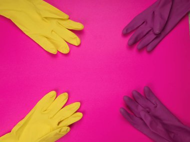 Pembe arka planda temizlik için lastik eldiven, ıslahevi konsepti. Ticari temizlik şirketi. Renkli lastik koruyucu eldiven giyen işçi elleri. Genel ya da düzenli temizlik. 