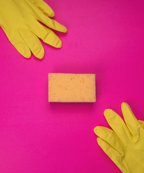 Sponge for washing dishes in hand. Hand in a latex glove isolated. A hand in a glove holds a sponge for washing and cleaning. Cleaning or housekeeping concept background. Frame for text or advertising