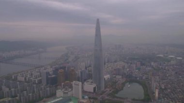 Puslu bir bulutlu gün hava video Lotte World Kulesi ve Jamsil dünyada Lotte. Seul 