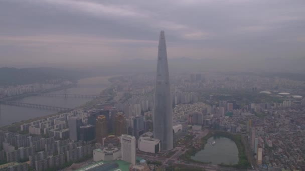 ぼんやりとした曇りの日に蚕室のロッテワールドとロッテワールド タワーの空中ビデオ ソウル — ストック動画
