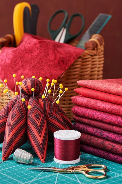 Conjunto de tecido vermelho e ferramentas de costura no tapete de artesanato — Fotografia de Stock