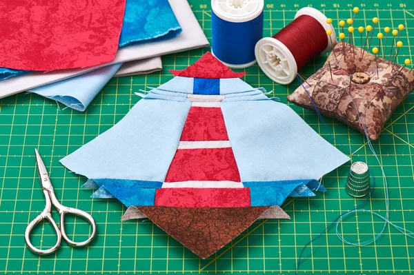 Sewing patchwork of block of lighthouse surrounded by accessorie — Stock Photo, Image