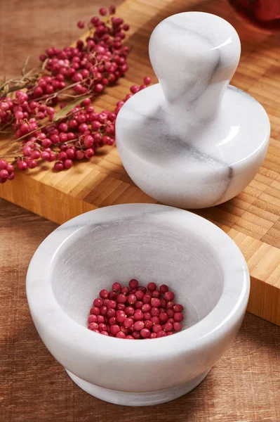 Dry rose pepper in white marble mortar next pestle — Stock Photo, Image
