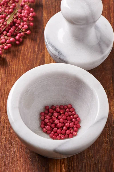 Droge roze peper in witte marmeren mortel volgende stamper — Stockfoto