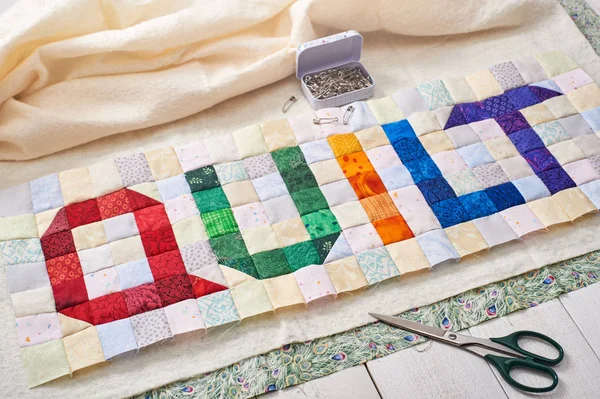 Das Wort Quilt aus bunten quadratischen und dreieckigen Stücken genäht — Stockfoto