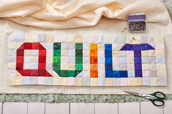 Das Wort Quilt aus bunten quadratischen und dreieckigen Stücken genäht — Stockfoto