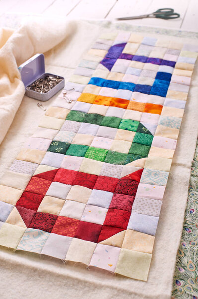 The word quilt sewn from colorful square and triangle pieces of 