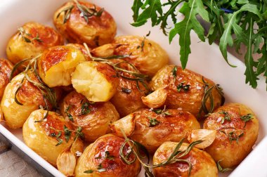 Kavrulmuş patates sarımsak, kekik ve biberiye seramik pişirme çanağı, yakın çekim