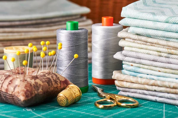 Verzameling pastel stoffen en naaien gereedschappen op ambachtelijke mat — Stockfoto