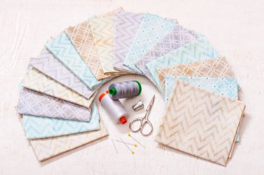 Pastel kumaşlar üzerinde daire ve dikiş araçları cen içinde düzenlenmiş kümesi