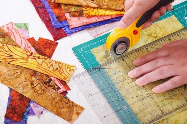 切割织物件的回转面刀具在垫子上使用规则的过程 — 图库照片