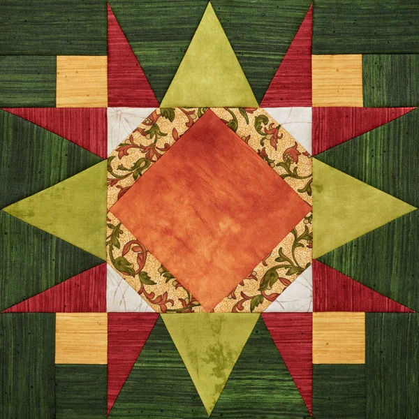 Bright orange-green geometric patchwork block from pieces of fabrics, detail of quilt — Stock Photo, Image