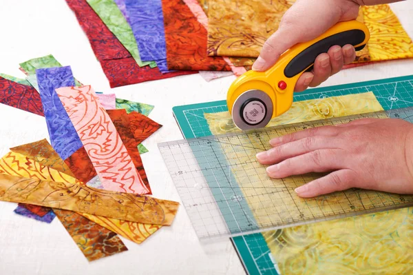 Processo de corte de peças de tecido por cortador rotativo no tapete usando régua — Fotografia de Stock