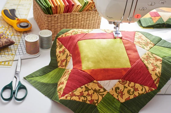 Лоскутное одеяло оранжево-зеленого цвета, стеганое одеяло, швейные принадлежности — стоковое фото