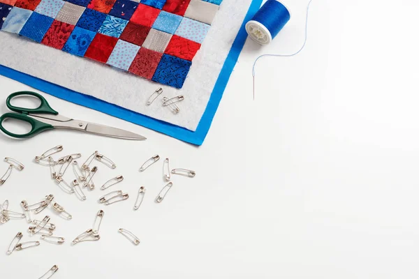 Assembling of a quilt sandwich, curved basting pins and sewing accessories, space for text — Stock Photo, Image