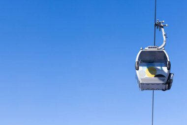 Mavi gökyüzünün arka planında kabin teleferik